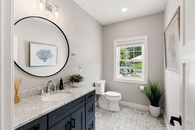 bathroom featuring tile patterned flooring, toilet, visible vents, vanity, and baseboards