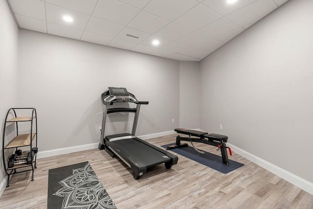 exercise room with light wood finished floors, visible vents, and baseboards