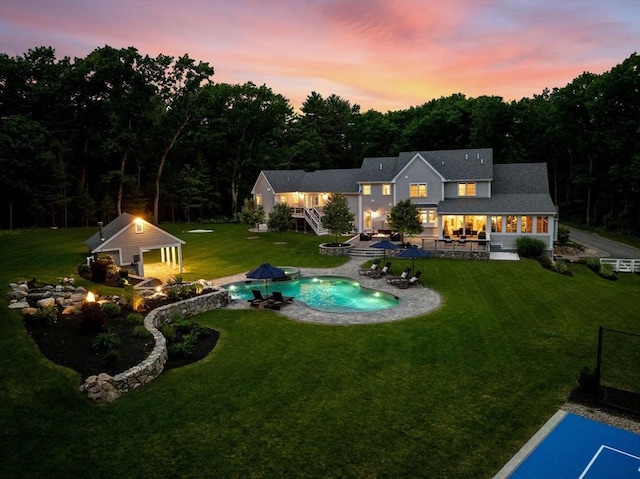 back of house with a lawn, a patio area, an outdoor pool, an outdoor structure, and stairs