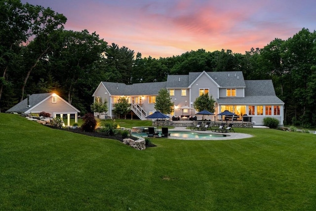 rear view of property featuring an outdoor pool, a lawn, a sunroom, stairs, and a patio area