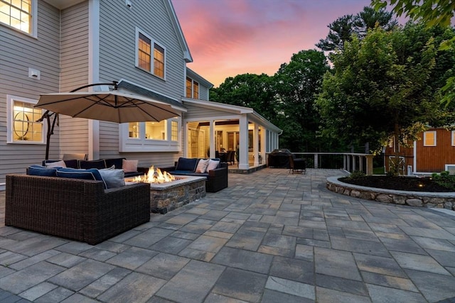 view of patio featuring grilling area, an outdoor living space with a fire pit, and fence