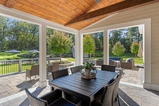 sunroom / solarium featuring lofted ceiling with beams and wood ceiling