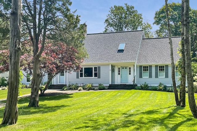 view of front of house featuring a chimney, a front lawn, and roof with shingles