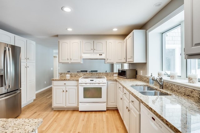 kitchen with appliances with stainless steel finishes, a sink, and white cabinetry