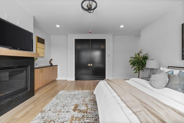 bedroom with light hardwood / wood-style floors and a closet