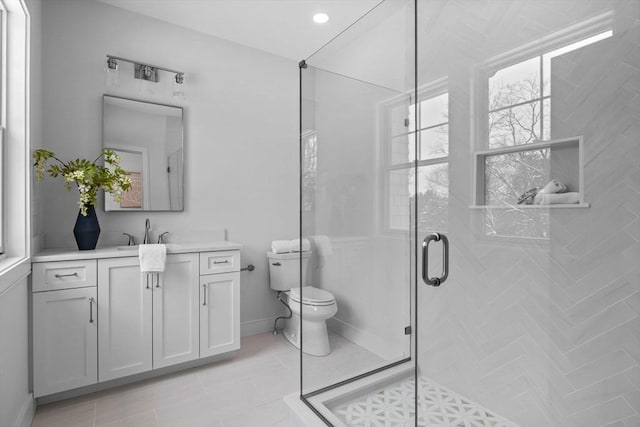 bathroom featuring walk in shower, vanity, toilet, and tile patterned flooring