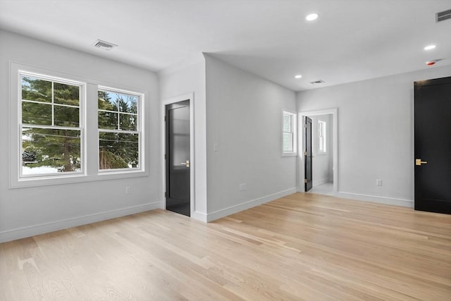 unfurnished bedroom with light hardwood / wood-style floors and multiple windows