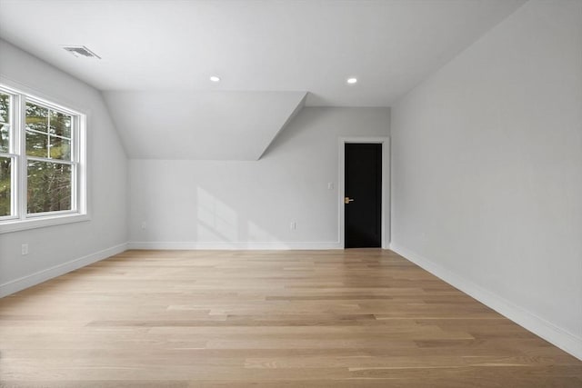 additional living space featuring light hardwood / wood-style floors and lofted ceiling