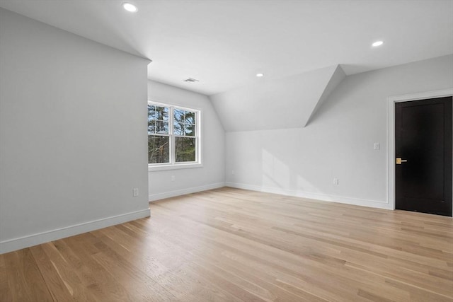 additional living space with lofted ceiling and light wood-type flooring