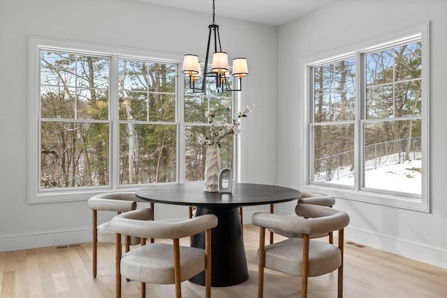 dining room featuring light hardwood / wood-style floors, a chandelier, and plenty of natural light