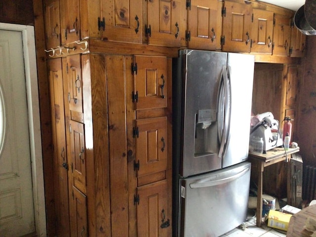 kitchen featuring stainless steel fridge and brown cabinets