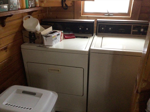 laundry area featuring laundry area, separate washer and dryer, and wood walls