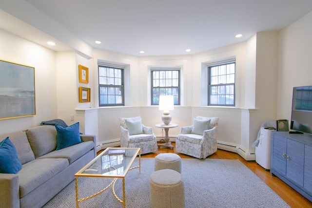 living room featuring a baseboard radiator, wood finished floors, and recessed lighting