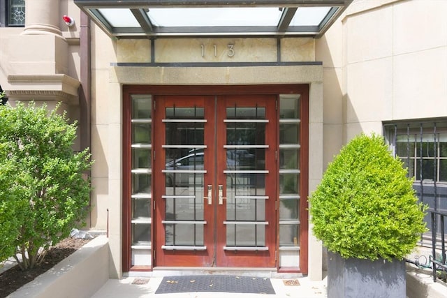 view of exterior entry featuring french doors and stucco siding