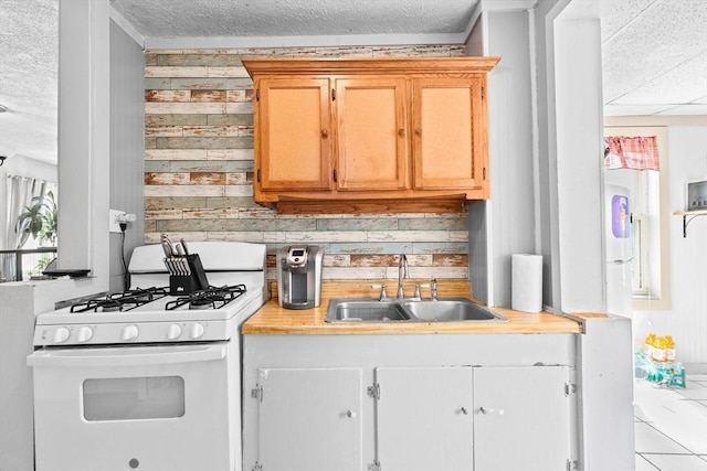 93 Warren, Fall River, MA 02721 - kitchen featuring white range with gas cooktop, a sink, light countertops, wooden walls, and a textured ceiling