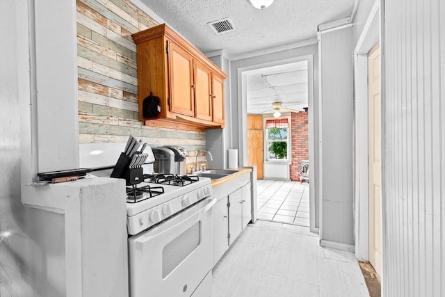 93 Warren, Fall River, MA 02721 - kitchen with a sink, white gas range oven, a ceiling fan, a textured ceiling, and wood walls