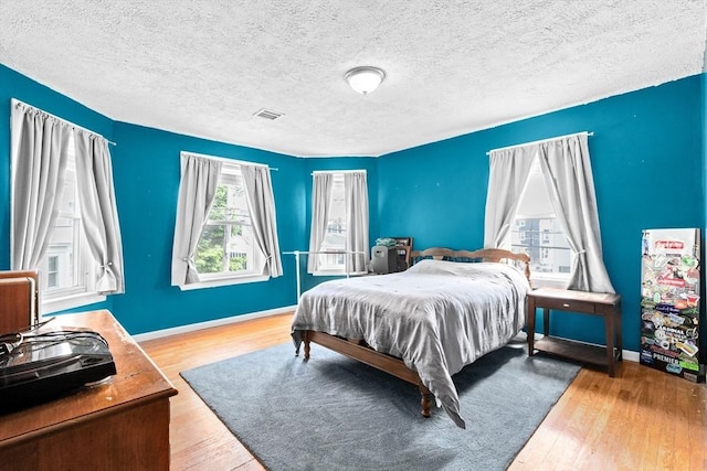 93 Warren, Fall River, MA 02721 - bedroom with multiple windows, wood finished floors, baseboards, and a textured ceiling