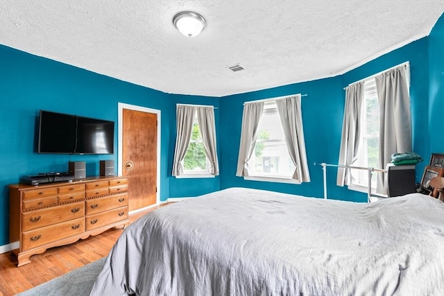 93 Warren, Fall River, MA 02721 - bedroom with wood finished floors, multiple windows, a textured ceiling, and baseboards