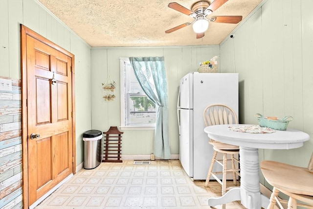 93 Warren, Fall River, MA 02721 - kitchen featuring freestanding refrigerator, light floors, a ceiling fan, ornamental molding, and wooden walls