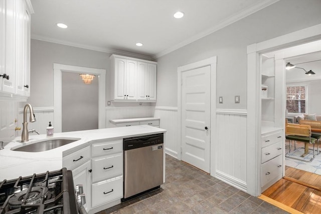 kitchen with a sink, white cabinetry, dishwasher, and a wainscoted wall