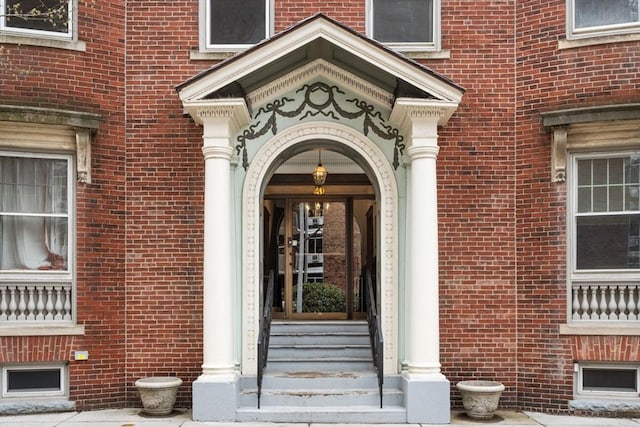 view of exterior entry featuring brick siding