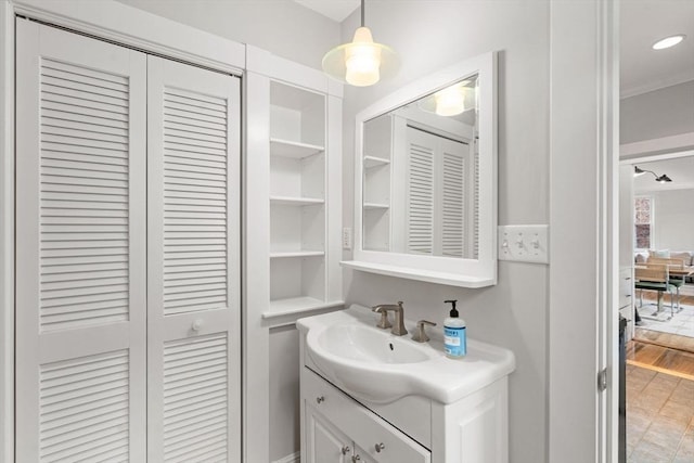 bathroom featuring vanity, ornamental molding, a closet, and recessed lighting