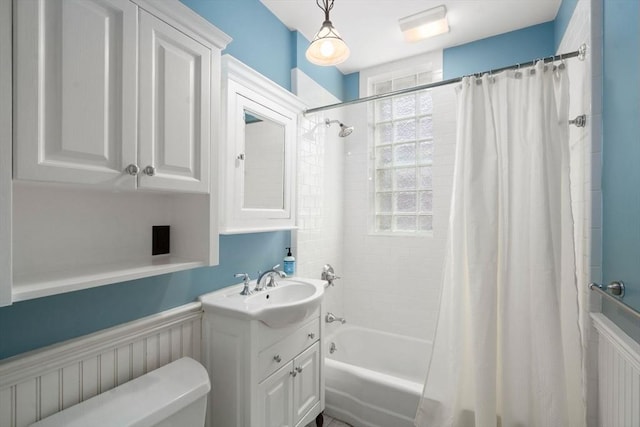 bathroom featuring vanity, toilet, wainscoting, and shower / tub combo with curtain