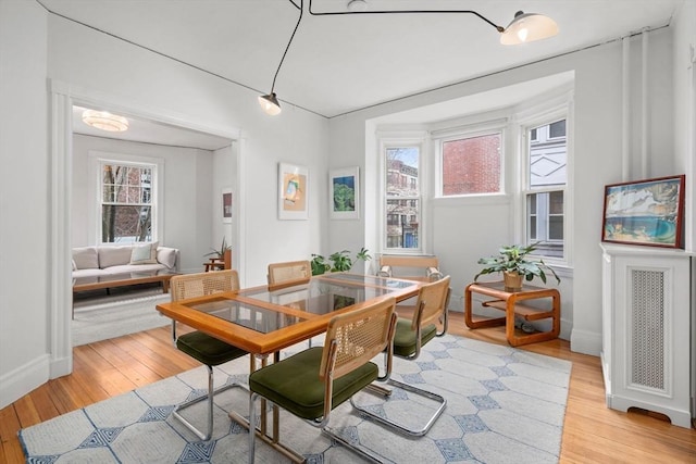 dining area featuring baseboards and light wood finished floors