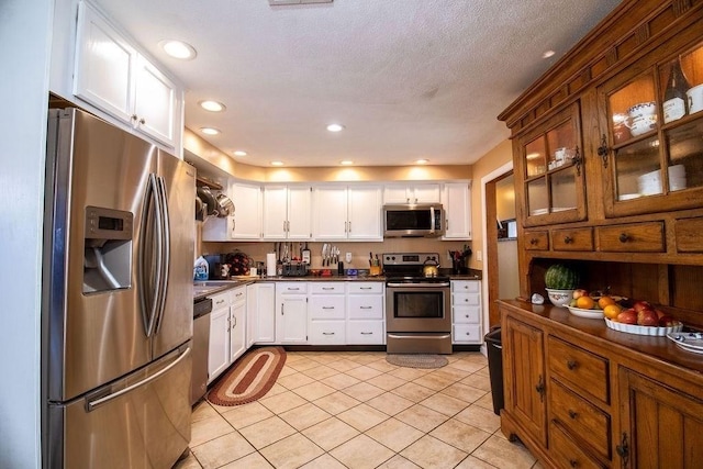 272 S Precinct, Taunton, MA 02718 - kitchen featuring stainless steel appliances, light tile patterned floors, white cabinets, and dark countertops