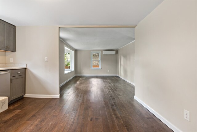 unfurnished living room featuring dark wood-type flooring, a wall mounted AC, and crown molding