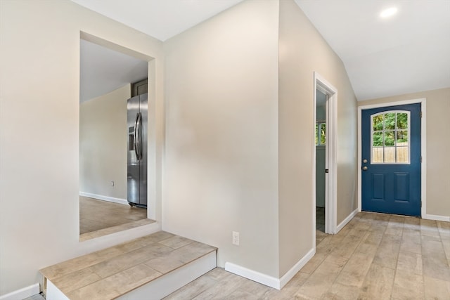 foyer with vaulted ceiling and light wood-type flooring