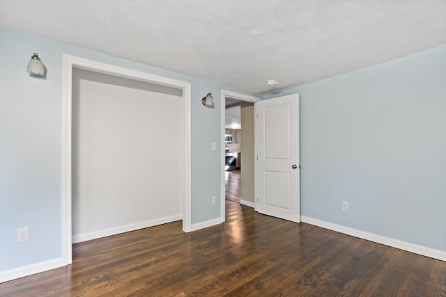 unfurnished bedroom featuring dark hardwood / wood-style flooring