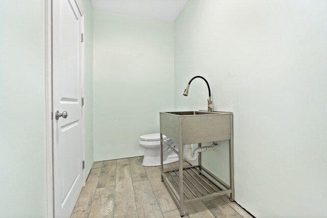 bathroom with hardwood / wood-style floors and toilet