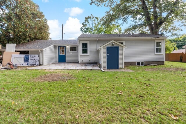 back of house with a patio area and a yard