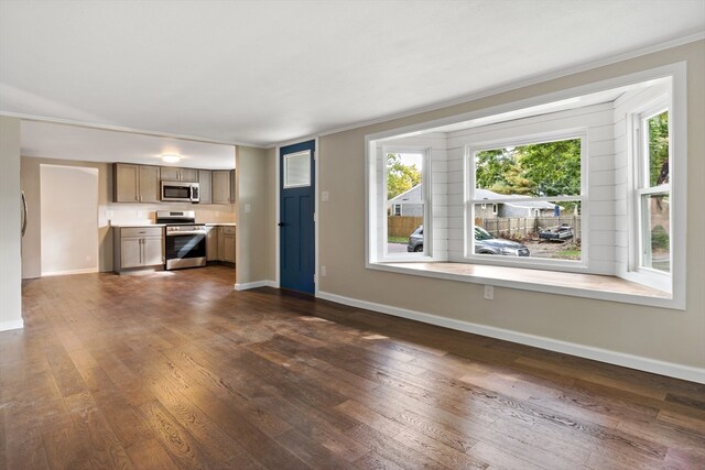 unfurnished living room featuring ornamental molding and dark hardwood / wood-style flooring