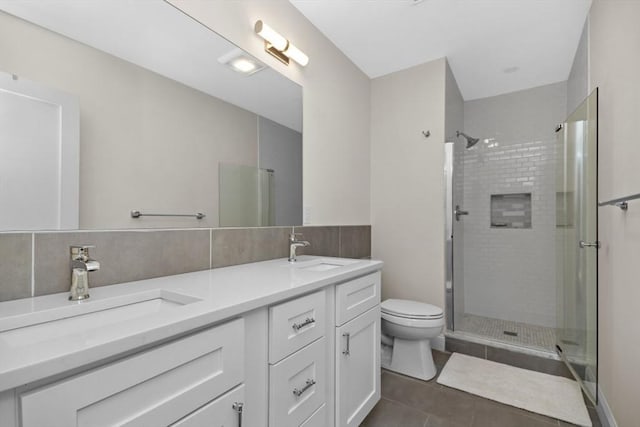 bathroom featuring backsplash, vanity, tile patterned flooring, toilet, and a shower with shower door