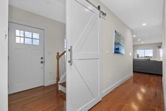 foyer with a barn door and hardwood / wood-style flooring