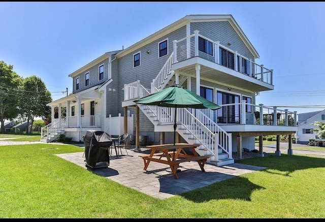 rear view of property featuring a patio area and a lawn