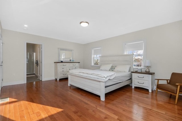 bedroom with dark hardwood / wood-style floors and ensuite bathroom