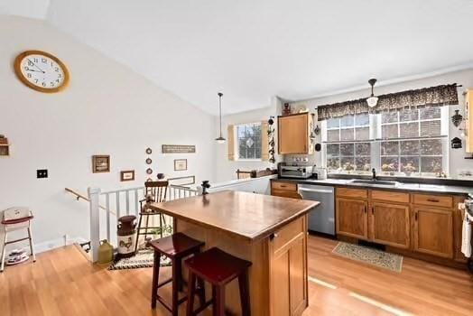 544 Lunns Way, Plymouth, MA 02360 - kitchen featuring stainless steel dishwasher, light wood-type flooring, brown cabinets, a center island, and a kitchen breakfast bar