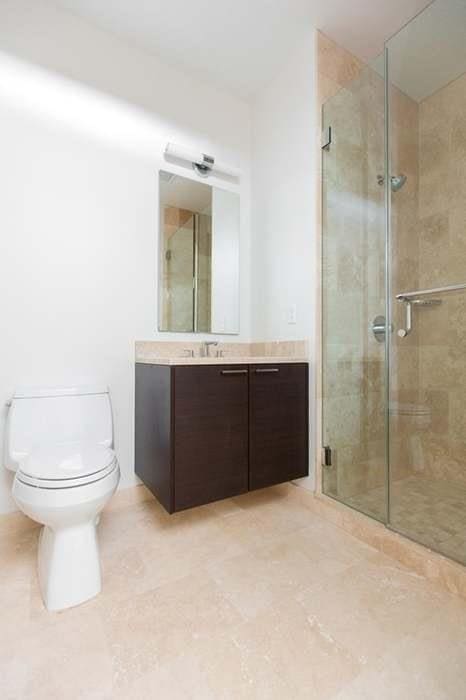 bathroom with toilet, vanity, tile patterned flooring, and an enclosed shower