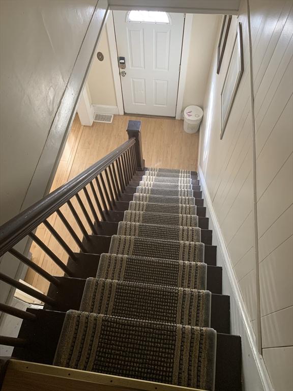 stairs featuring hardwood / wood-style floors