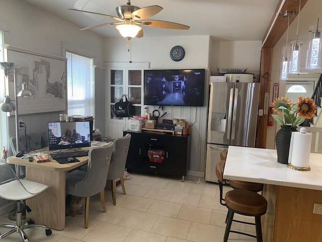 kitchen with ceiling fan, a kitchen breakfast bar, decorative light fixtures, and stainless steel fridge with ice dispenser