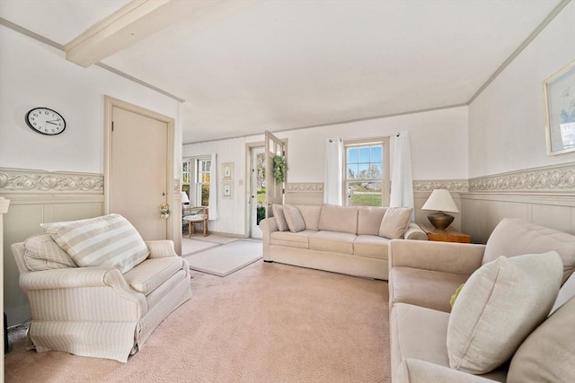 carpeted living area with a wainscoted wall