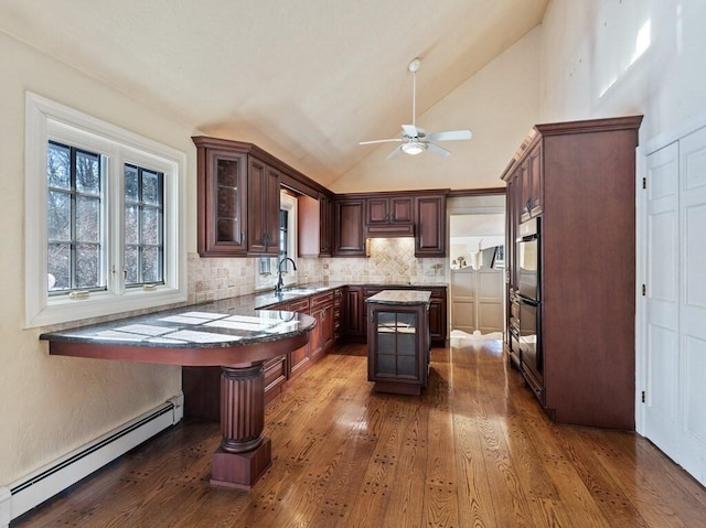 kitchen with baseboard heating, a center island, dark wood-type flooring, and decorative backsplash