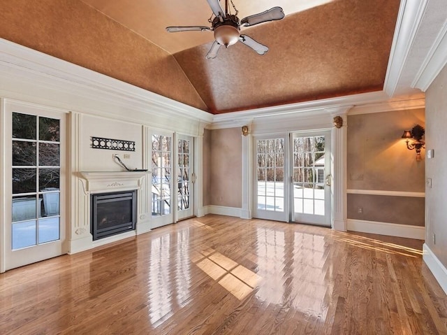 unfurnished living room featuring vaulted ceiling, hardwood / wood-style floors, ceiling fan, and crown molding