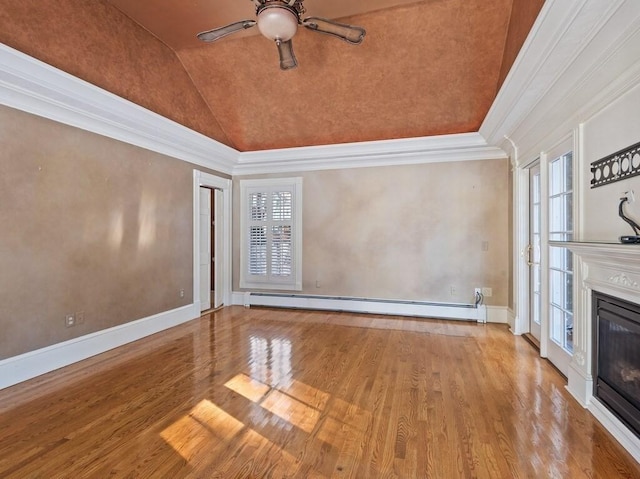 unfurnished living room with lofted ceiling, crown molding, baseboard heating, hardwood / wood-style floors, and a healthy amount of sunlight