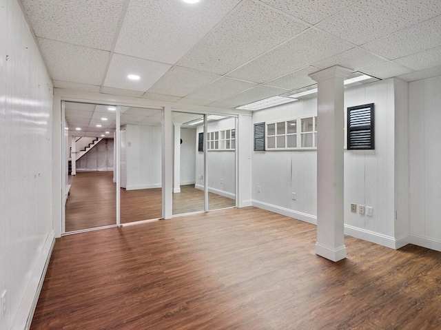 basement featuring wood-type flooring and a paneled ceiling