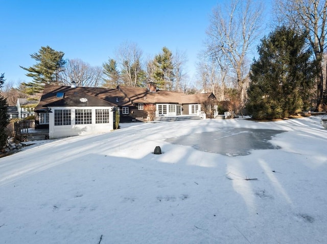 view of snow covered rear of property