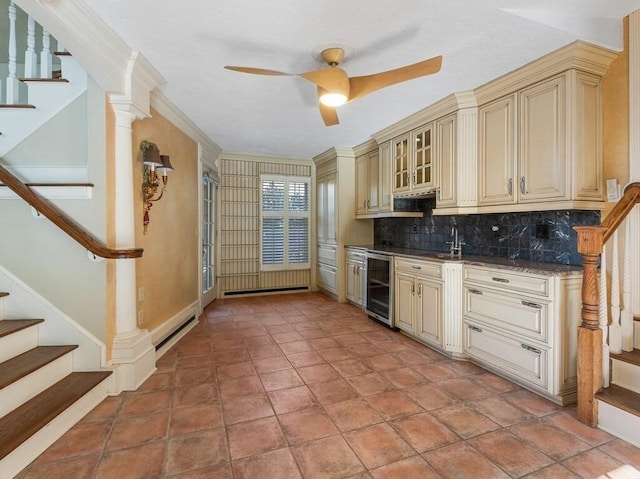 kitchen with crown molding, beverage cooler, cream cabinets, and backsplash